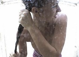 Девушка моется в душевой пляжной кабинке